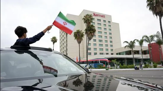 A-person-waves-an-Iranian-flag-from-a-vehicle-outs_1781108357391